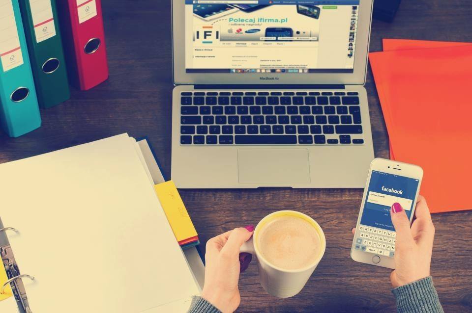 Laptop, telefoon, koffie en mappen op een bureau, van bovenaf gezien