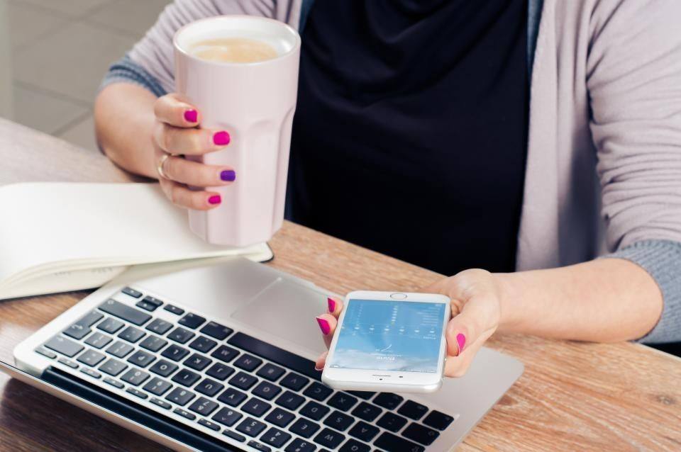 Telefoon en laptop naast elkaar op een tafel